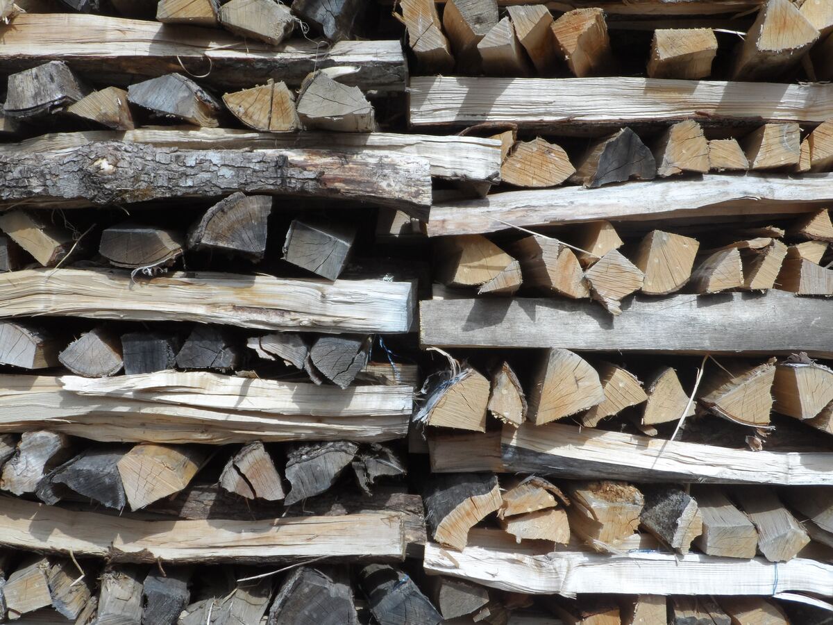 A stacked cord of firewood with weathered gray ends