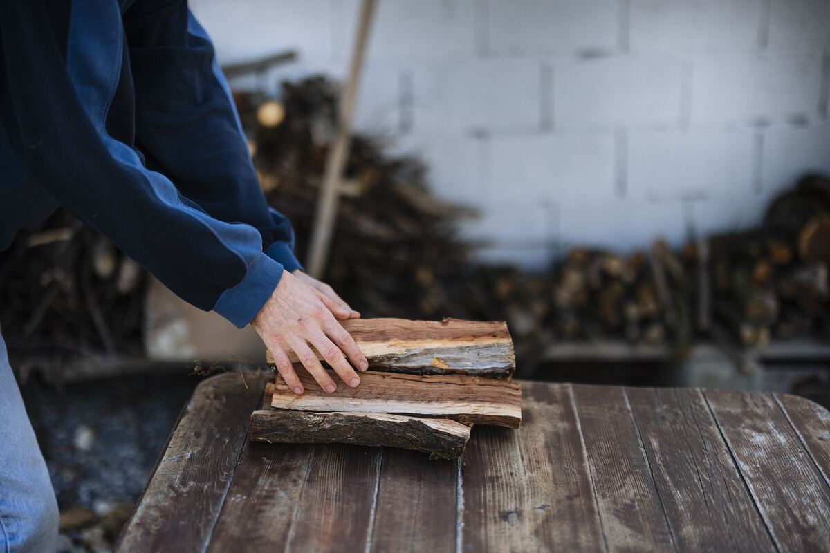 Hands holding split pieces of firewood